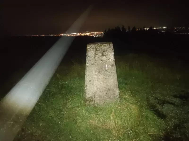 Concrete Trig Pillar of Woodcock Hill under the light of the torch