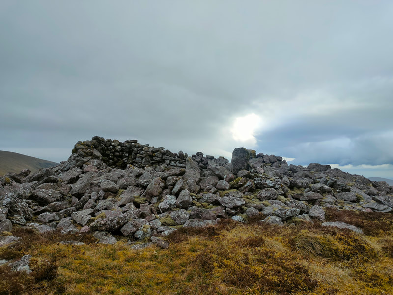 Cairn of stones on top of Fearbreaga, dark skies