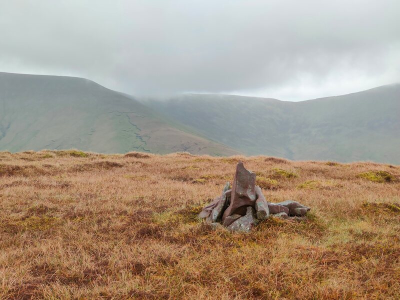 Brown surface of the top of Knockaterriff with a few stones as a mark, remaining Galty mountains in the background