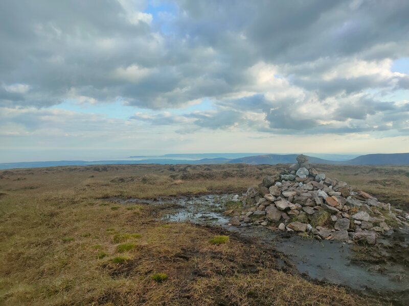 Small pile of stones marking the top of Kilclooney Mountain. Helvic Head in the background