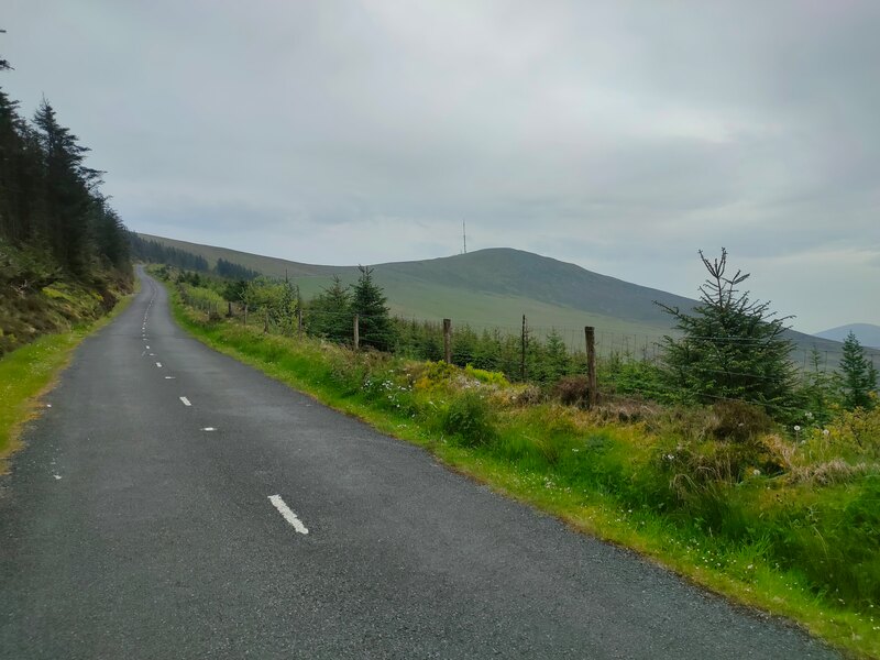 Tarred road with broken white line with Mount Leinster and mast on horizon