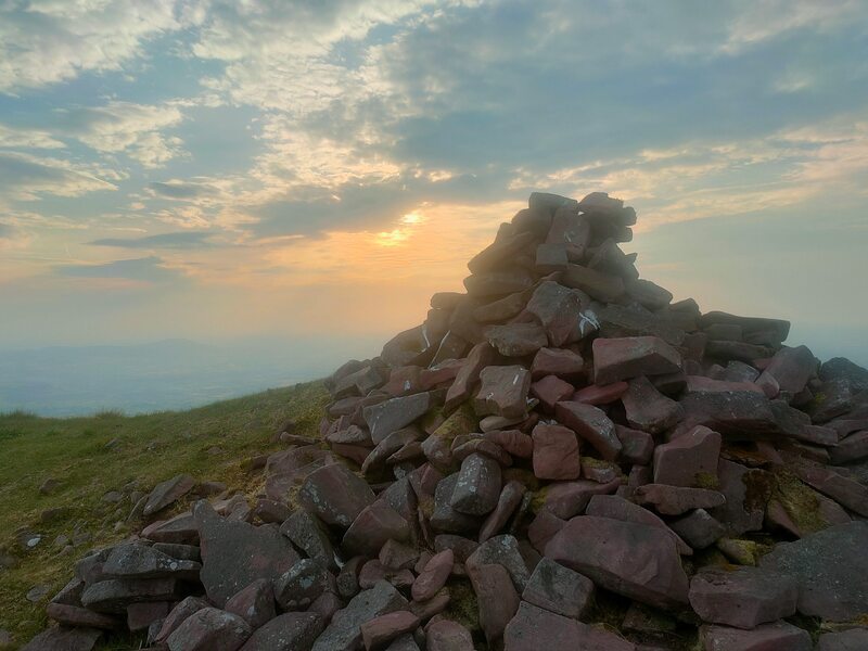 Pile of stones mark the top of Lyracappul with sun starting to set behind