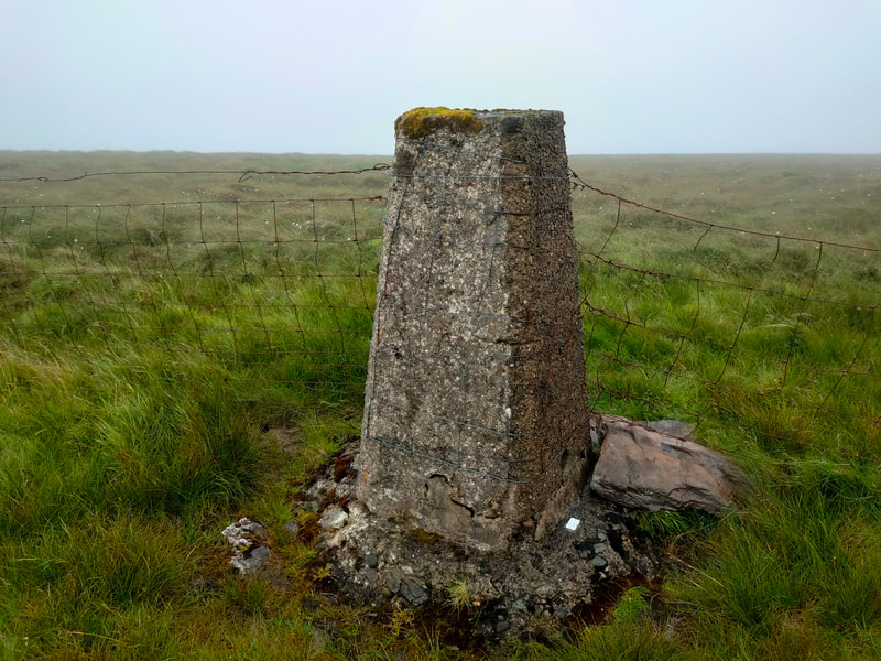 Caherbarnagh Trig Pillar with wire fence on each side