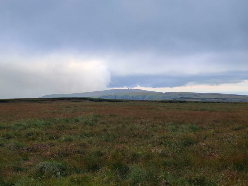 Seefin mountain outline against a cloudy sky with brown and green surface of Coumfea in the foreground