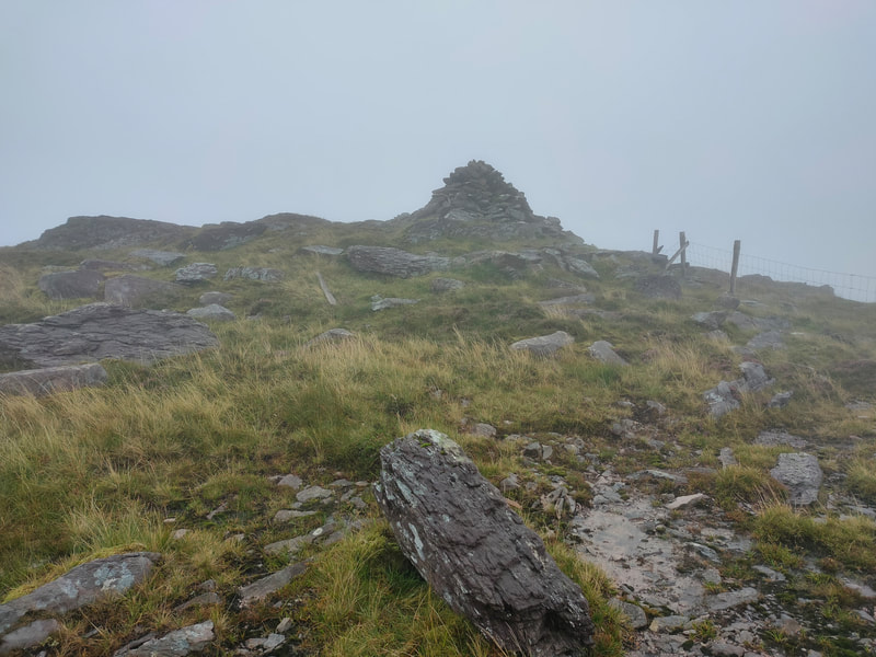 Pile of stones at the top of an overcast Knocknagantee