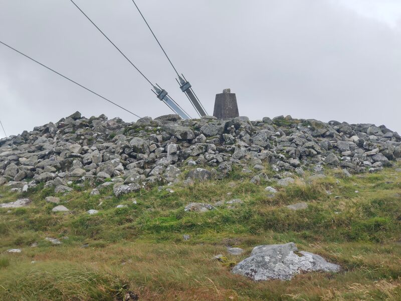 Mount Leinster Trig Pillar in mound of stones with ties of Mast also visible
