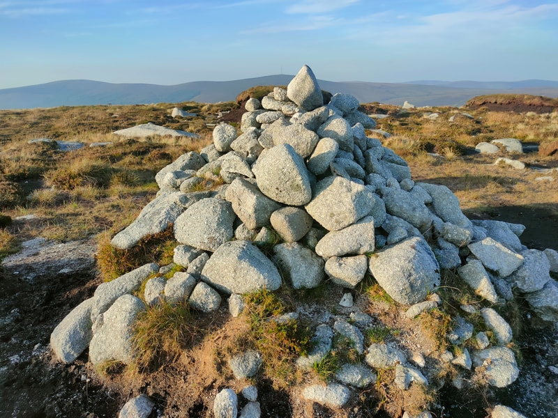A pile of stones mark the top of Gravale with Kippure mountain in the background.