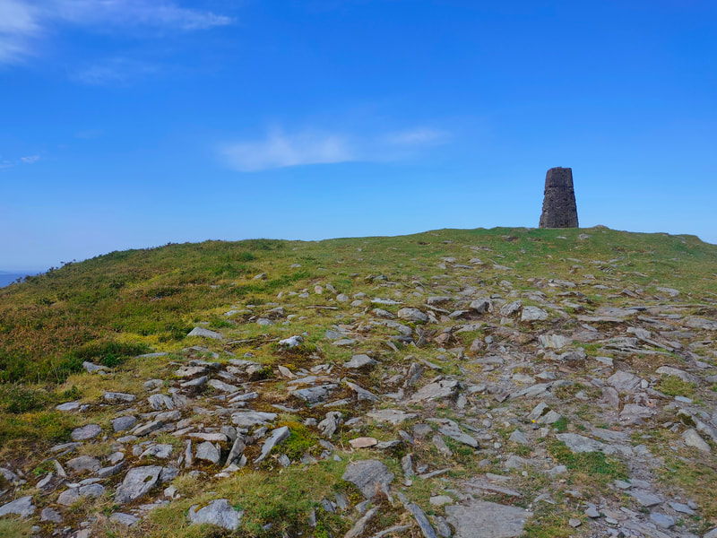 Trig Pillar on mountain top against almost completely blue sky