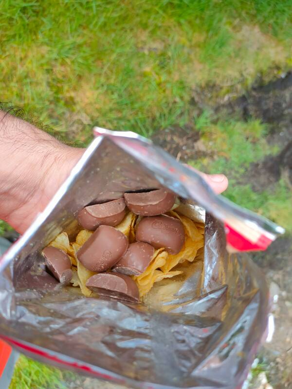 Looking inside a crisp bag with Tayto Crisps and broken up chocolate bar inside.