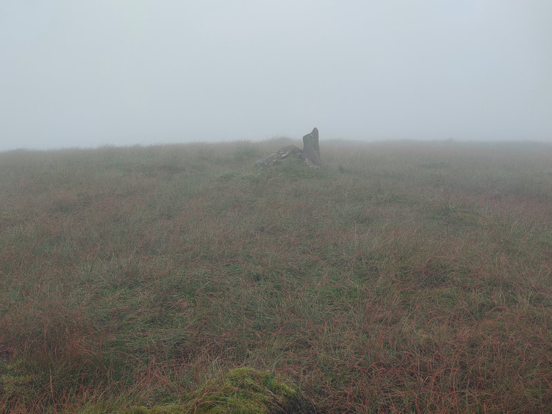 A misty mountain top with a few stones as a marker