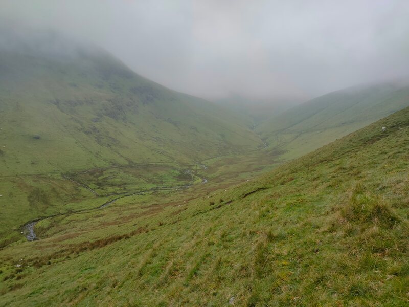 Meandering stream in the green Valley with low cloud
