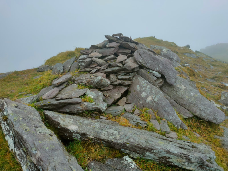 Pile of stones mark the top of Cnoc an Chuillin