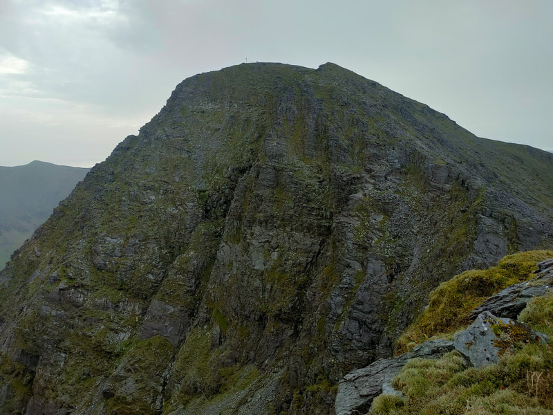 Carrauntoohil Mountain, cross and person visible on top.